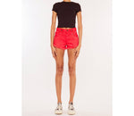 A pair of bright coral denim shorts with a high waist and frayed hem.