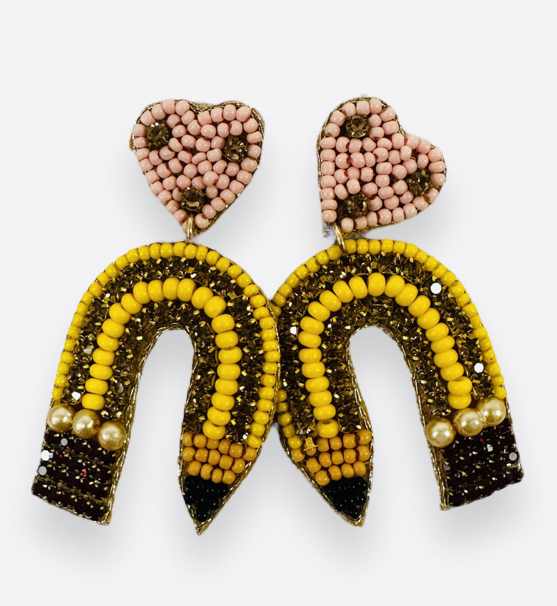 A pair of beaded earrings in the shape of a heart and curved pencil.