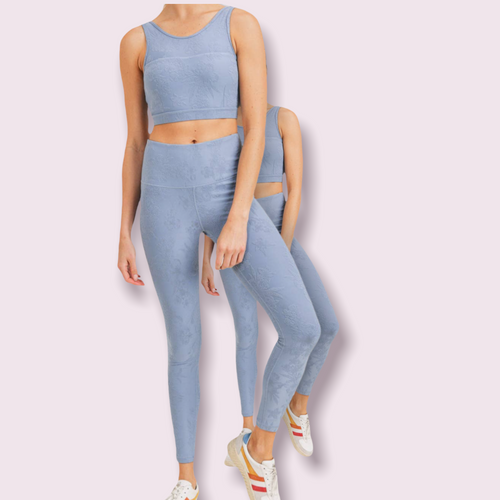 A pair of blue-grey high waisted leggings with a lace texture throughout.